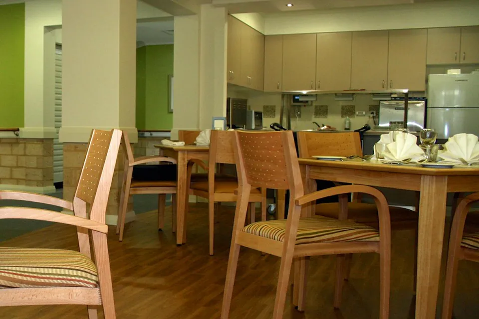 Communal dining table beside an open kitchen.