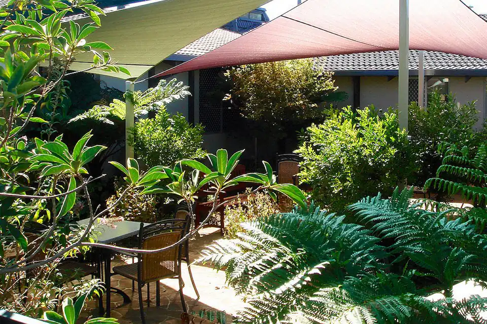 Shaded garden courtyard with outdoor seating.