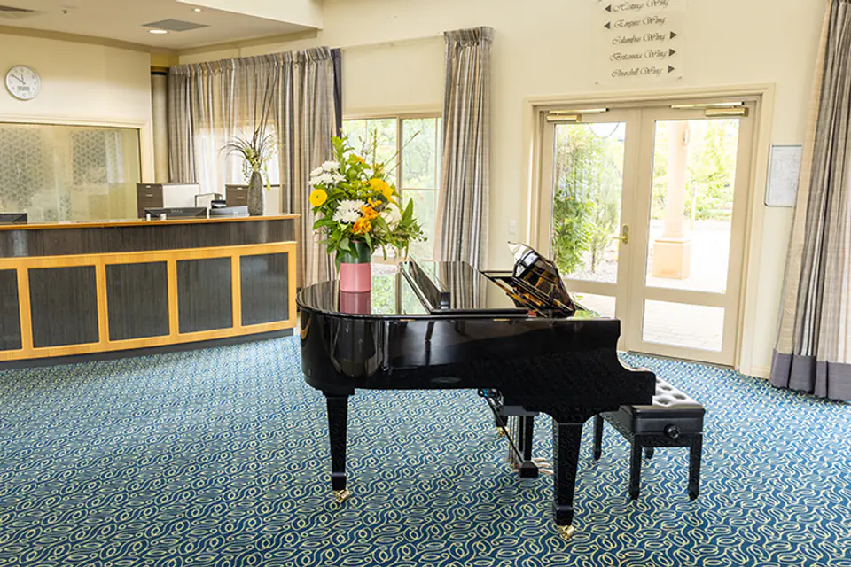 Lounge with a piano and garden windows