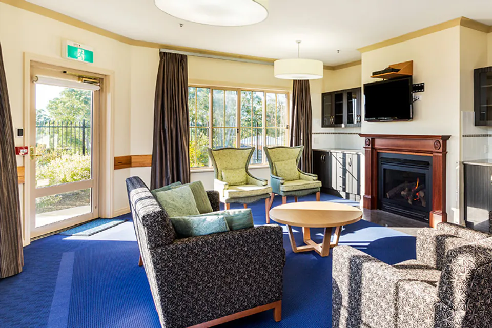 Lounge with armchairs and a kitchen behind them