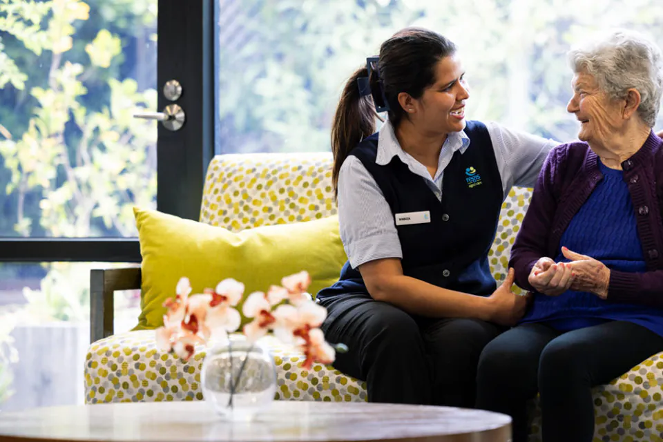 Staff member sitting with an older woman