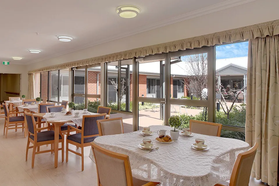 Dining area with large windows overlooking the courtyard