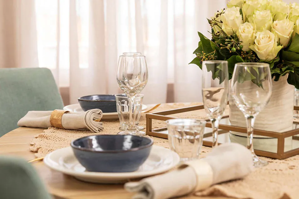 Dining place setting beside a vase of flowers