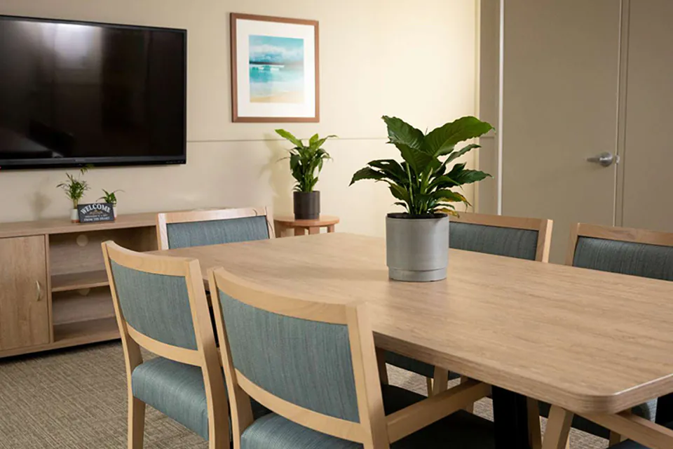 Dining table beside a television cabinet