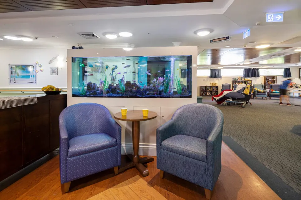 Fish tank beside armchairs in the lounge