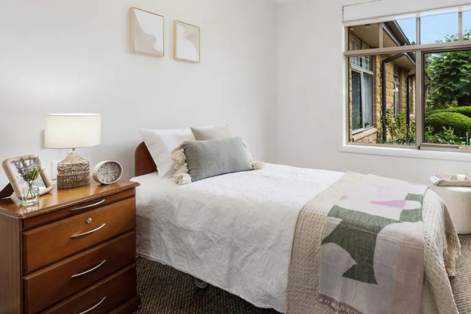 Bedroom with a single bed between windows