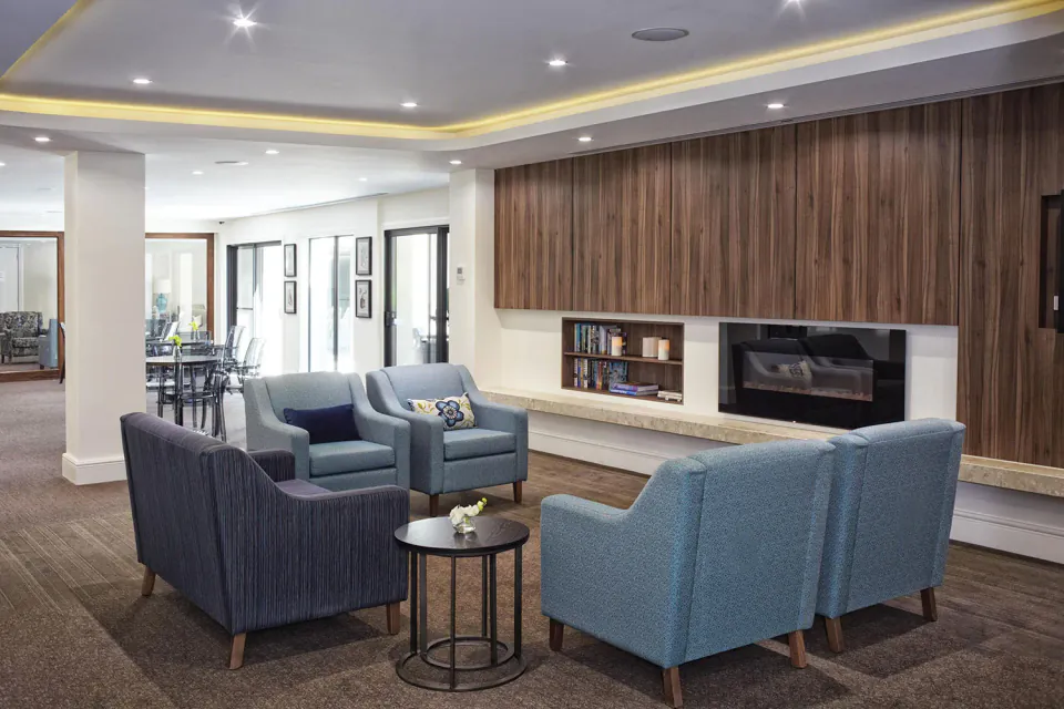 Lounge with blue armchairs beside a fireplace