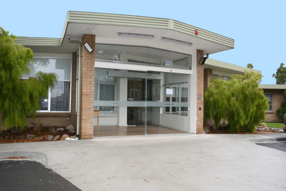 Brick residence entrance and covered drop-off area.