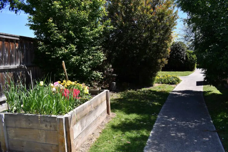 Raised flower bed beside a garden path.