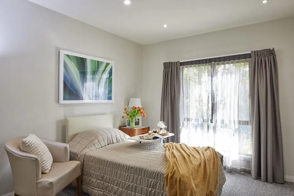 Bedroom with a bed and window overlooking greenery