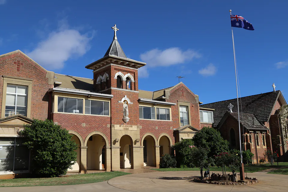 Red brick residence with a central tower and flagpole