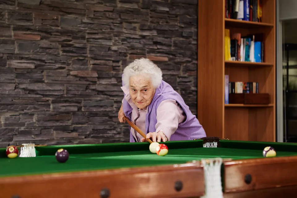 Resident leaning over a billiards table