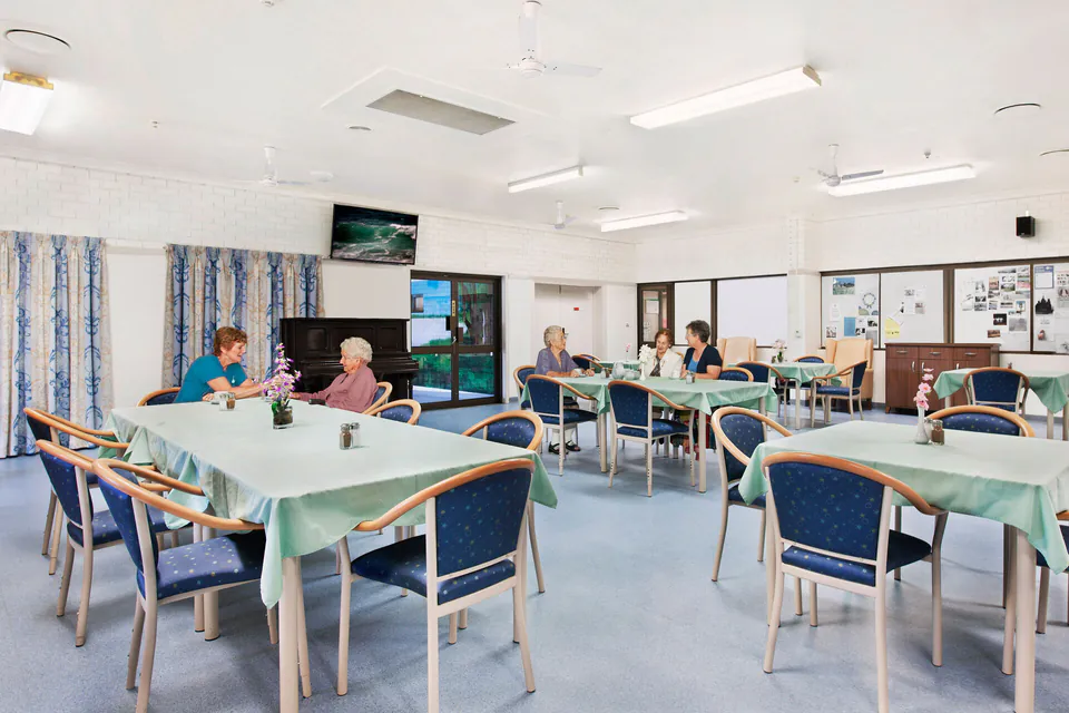 Residents and staff seated in the dining room