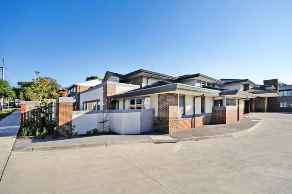 Low-rise residence buildings beside a paved driveway.