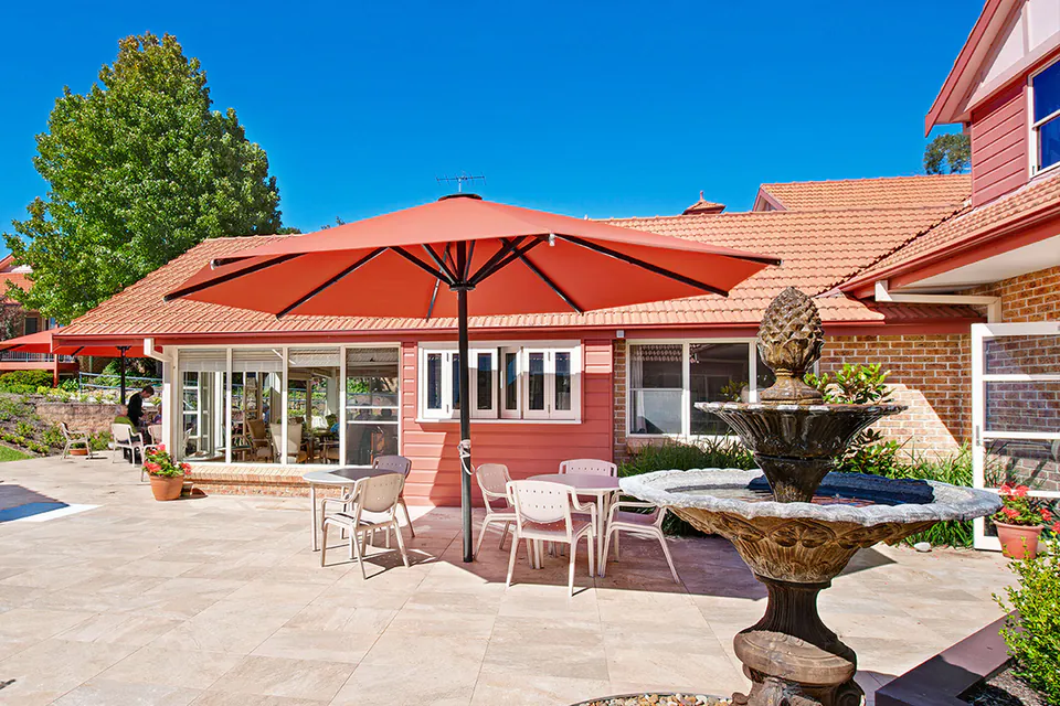 Brick residence and outdoor patio beneath red umbrellas