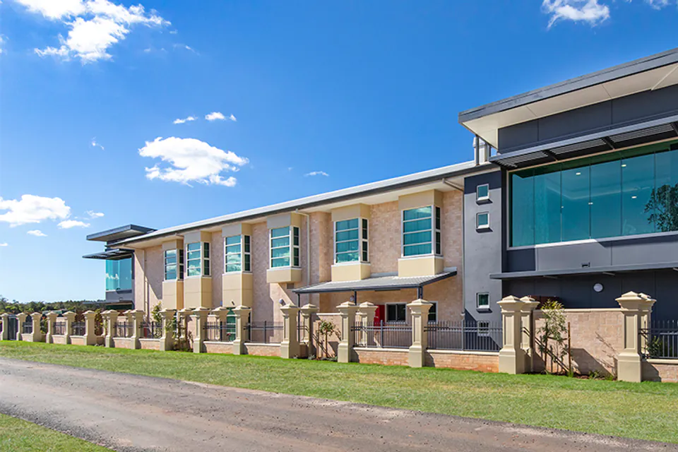 Long multi-storey residence beside a driveway