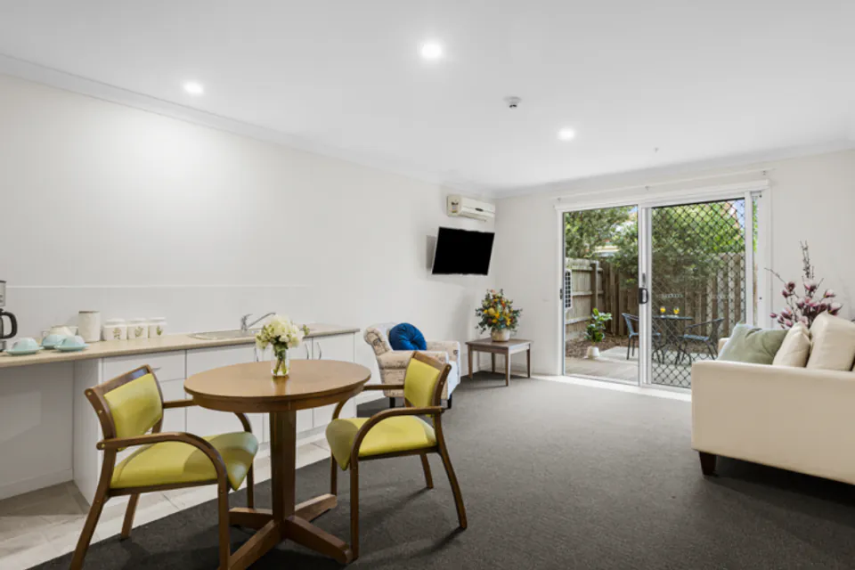 Resident sitting and dining area opening to a patio.