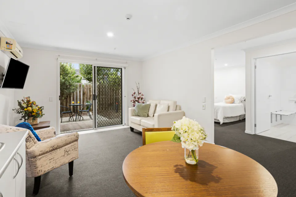 Sitting area with sofas and a round table beside patio doors.