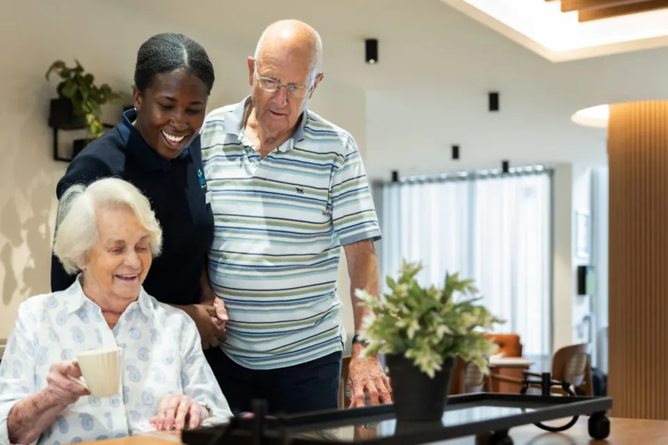 Residents talking with a staff member over tea