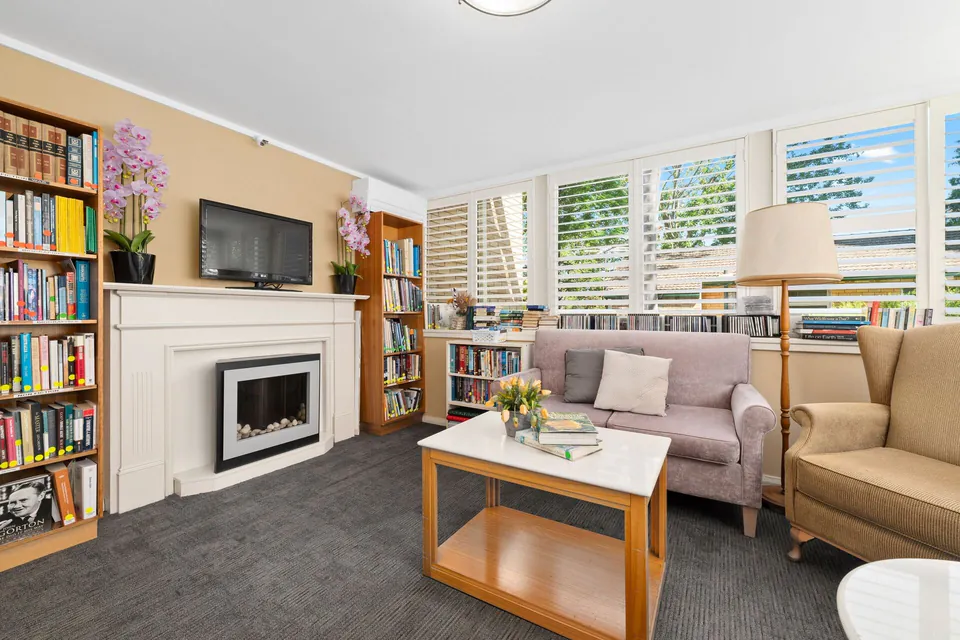 Living room with sofas, bookshelves and a fireplace