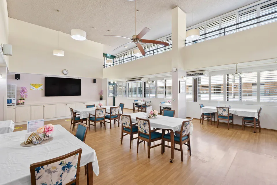 High-ceiling dining room with tables and chairs