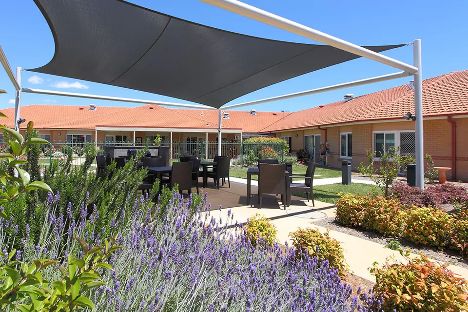 Shaded outdoor seating beside lavender garden beds