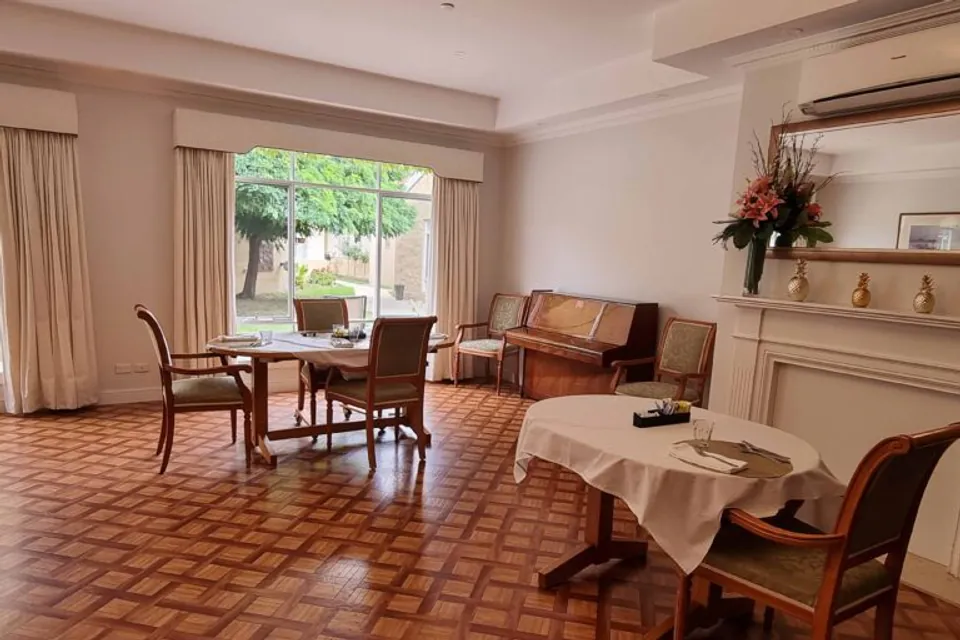 Communal sitting and dining room with a fireplace.
