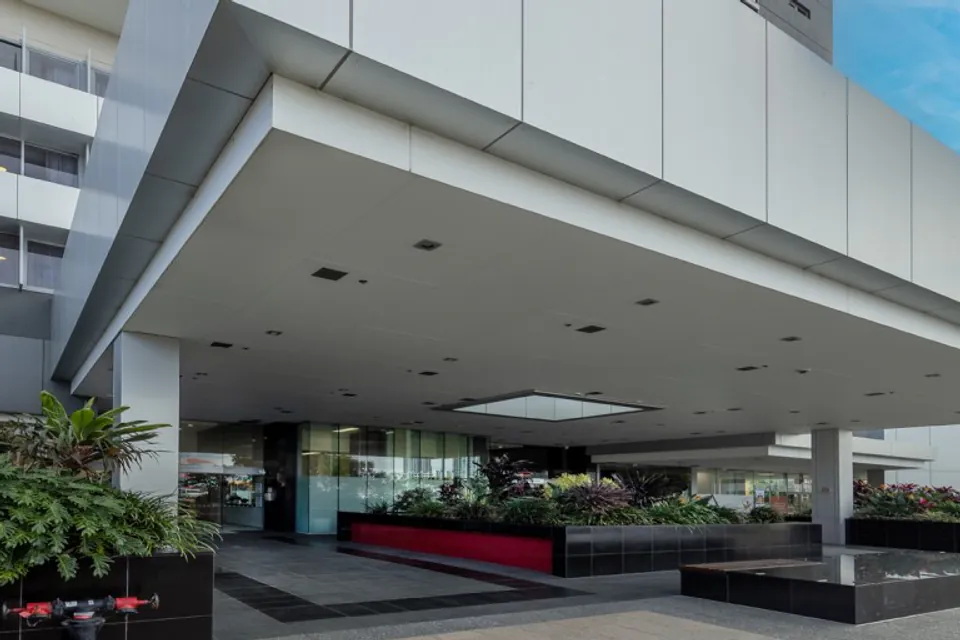 Covered entrance beneath a modern multi-storey building