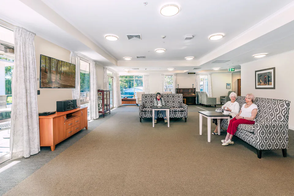 Residents chatting in a long shared lounge