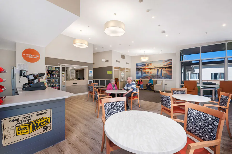 Residents at tables in a bright café area