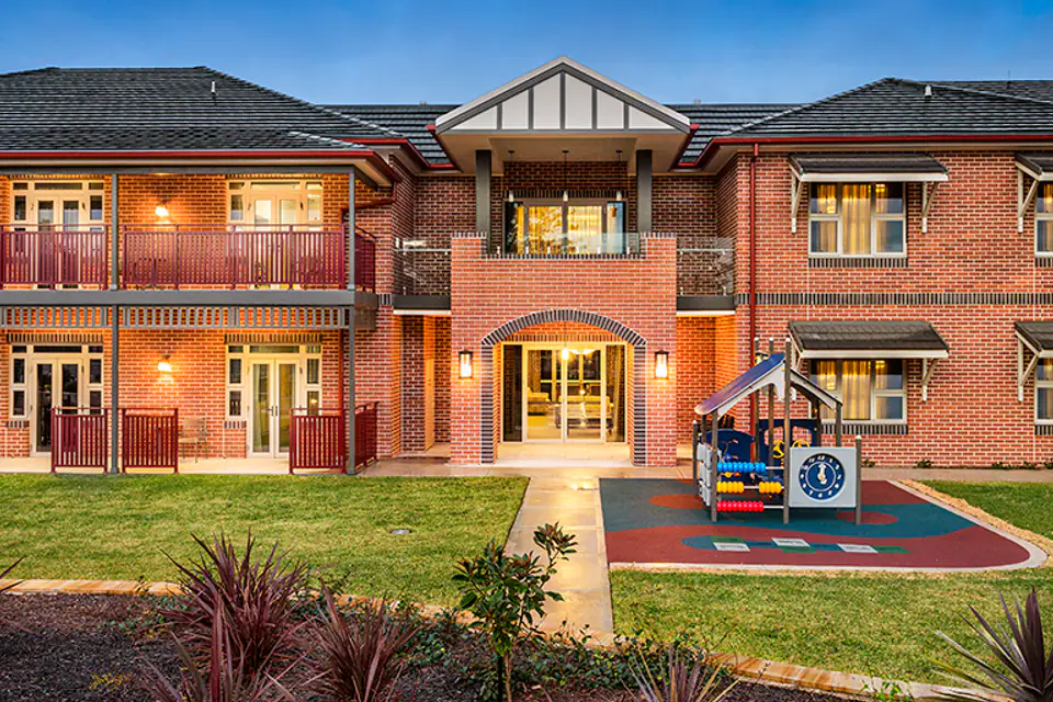 Brick entrance with balconies and a landscaped path