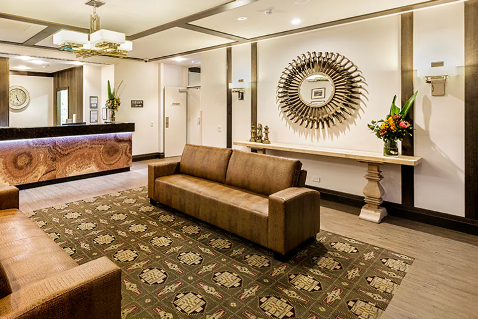 Reception desk and lounge seating beneath a coffered ceiling