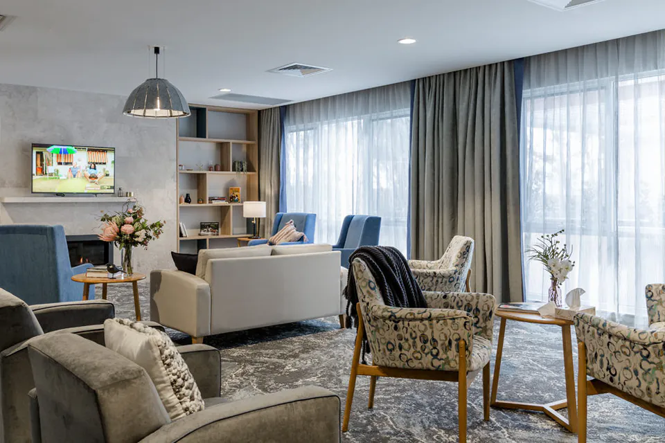Shared lounge with television and armchairs