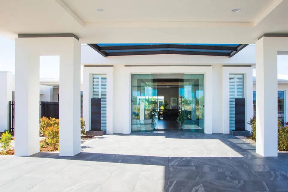 Covered entrance with glass doors and white columns