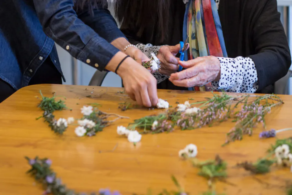Staff member helping a resident arrange flowers