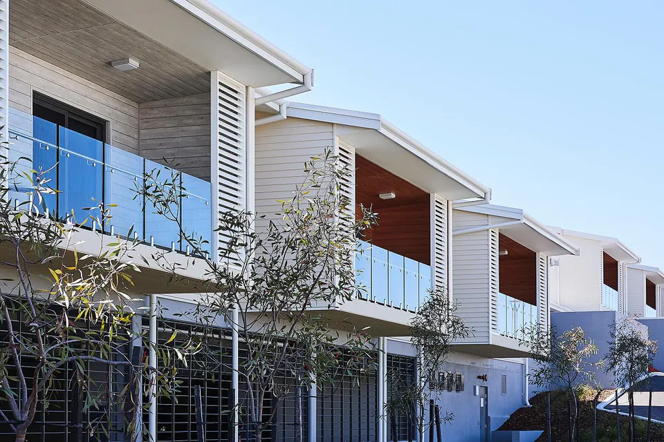 Upper balconies and pale cladding along the residential wing.