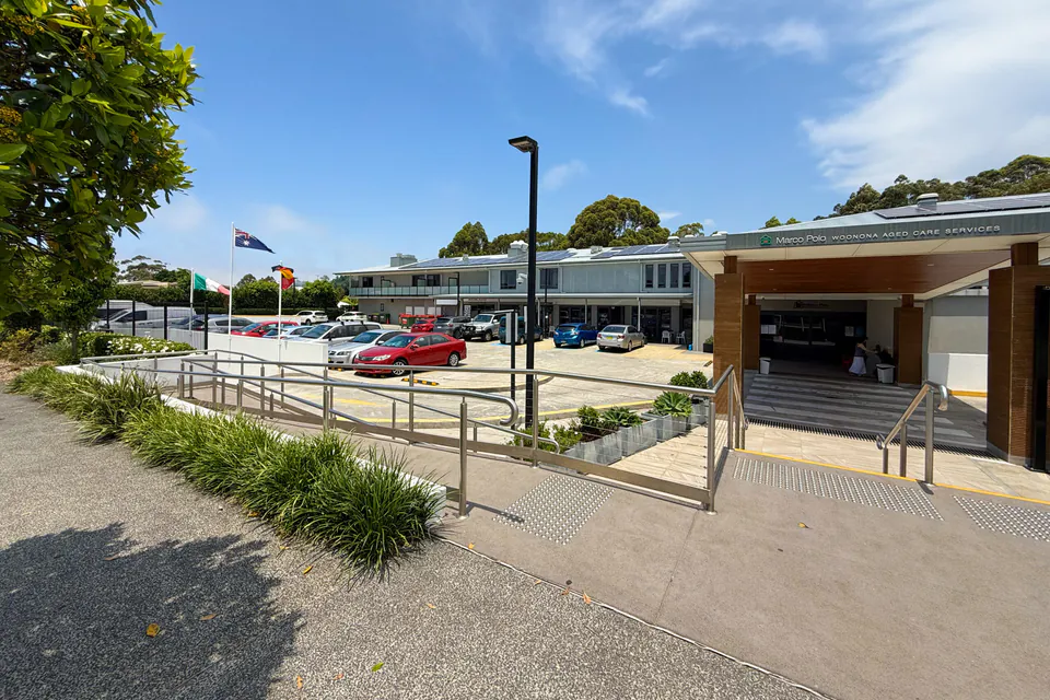 Long low care building and parking area beside a public footpath