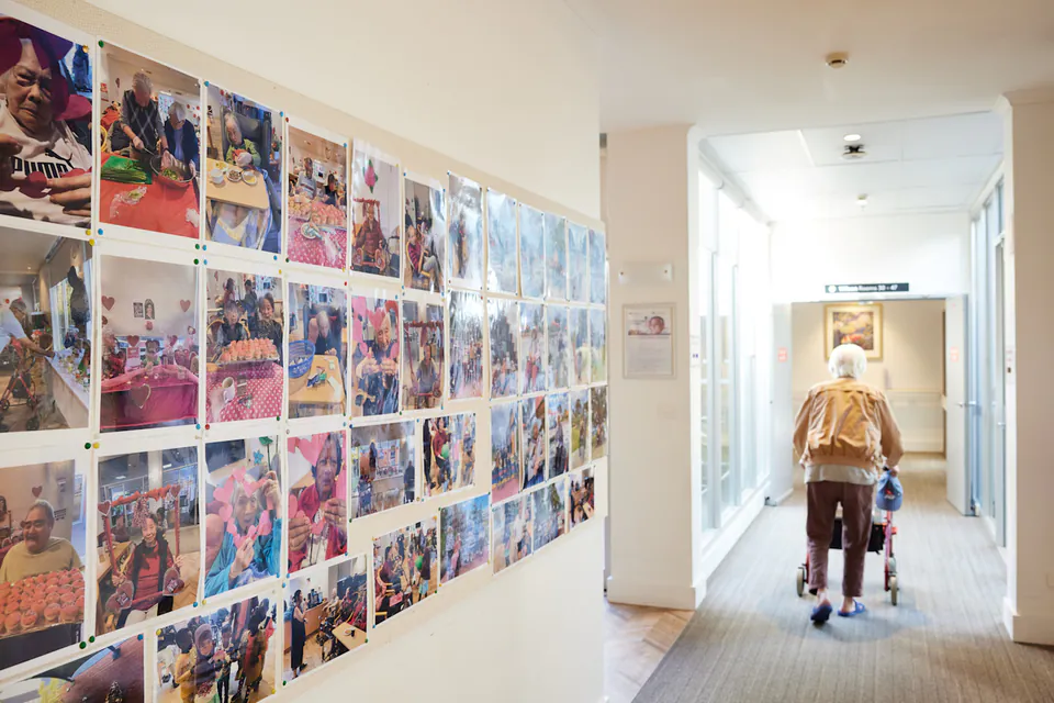Hallway lined with resident photographs and a person walking