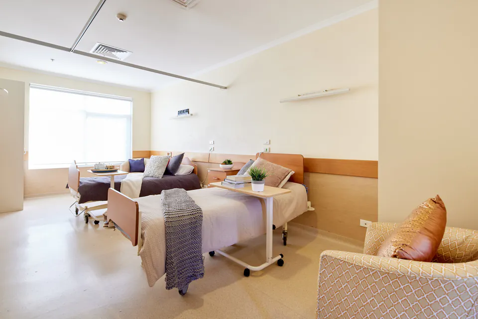 Bedroom with a single bed, armchair and pale quilt