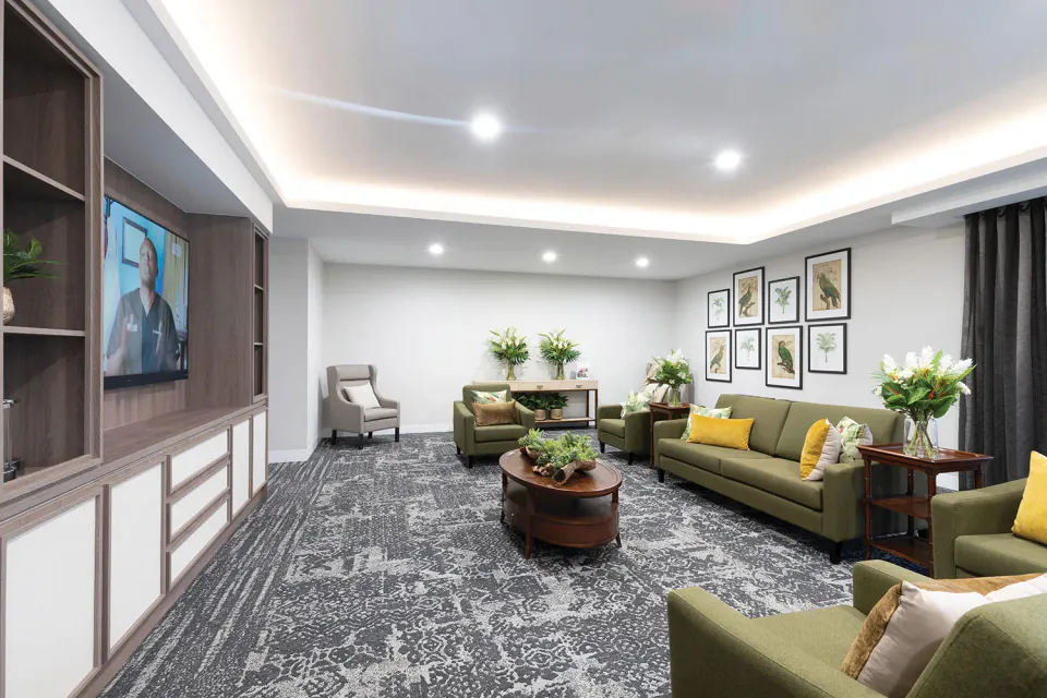Living room with green sofas and a television