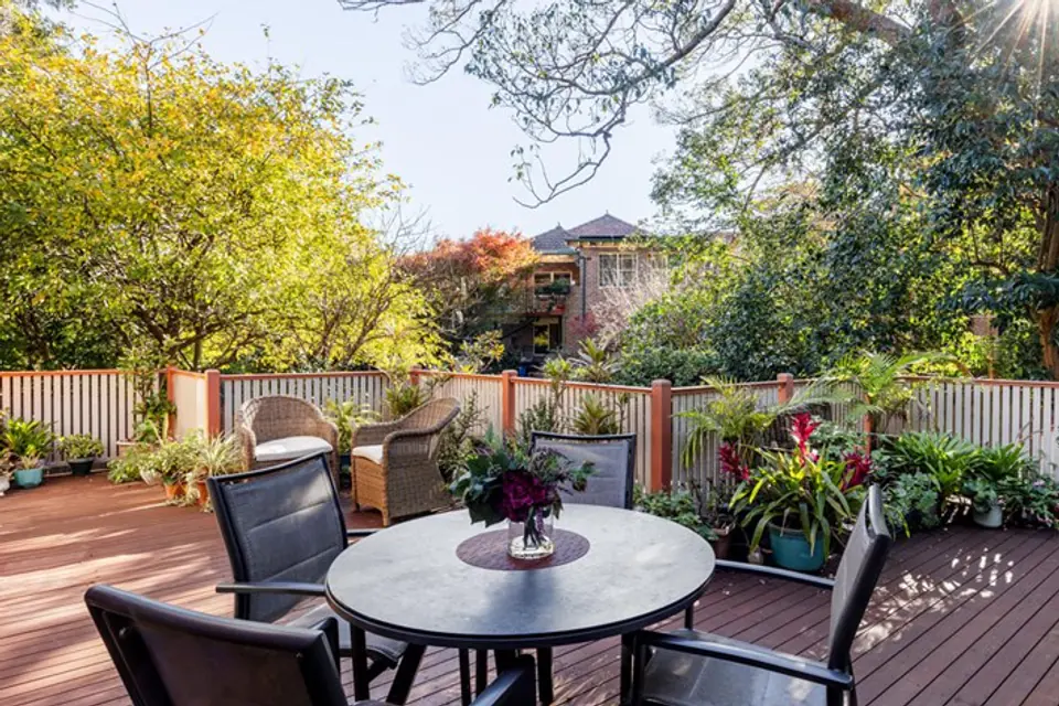 Outdoor dining table on a leafy deck