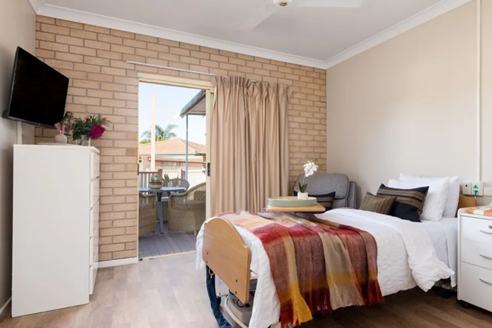 Resident bedroom with brick wall and garden window
