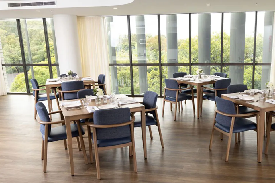 Dining room with tables beside tall windows
