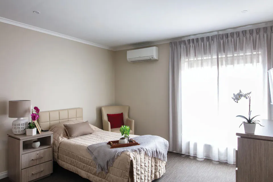 Bedroom with a single bed and curtained window