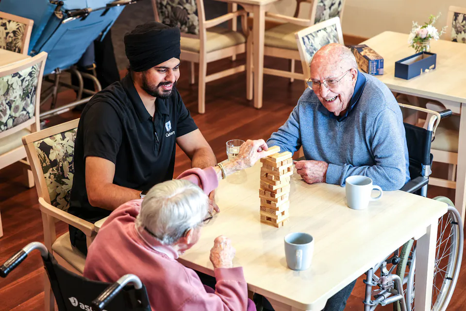 People gathered around a table game in the dining room