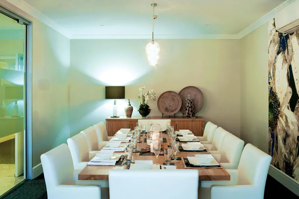Private dining table set beneath pendant lights
