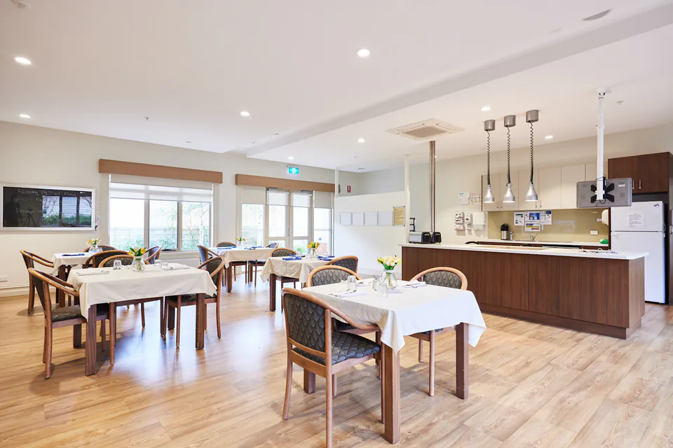 Dining area with tables beside a kitchen counter