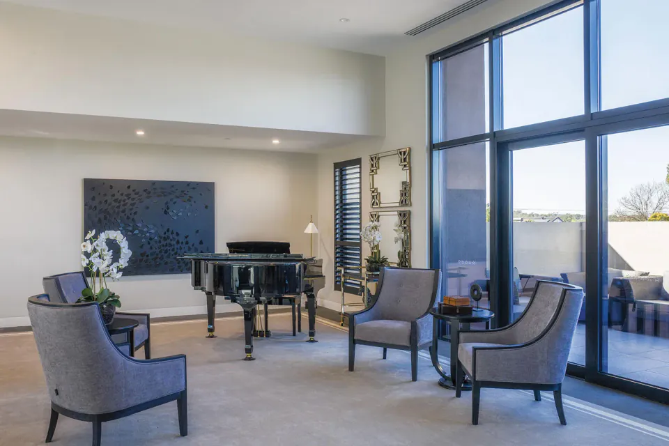Sitting area with grand piano beside patio doors
