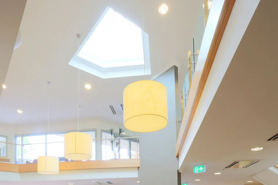 Sunlit lounge with chairs beneath a skylight