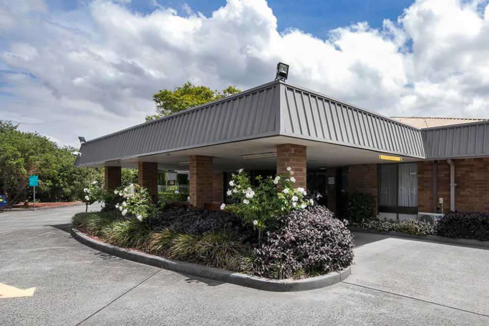 Single-storey building entrance with a covered driveway